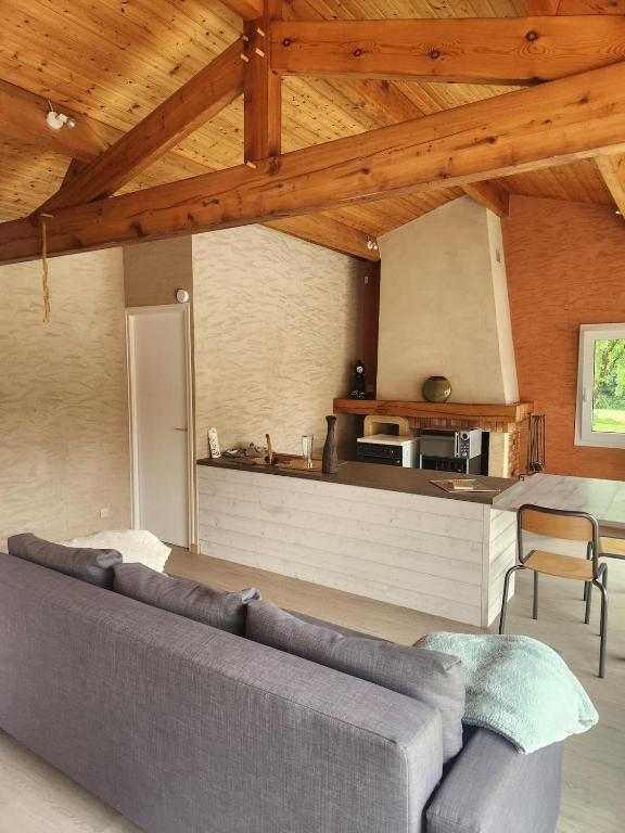 a living room with a couch and a kitchen at Bienvenue chez nous ! in Combrand