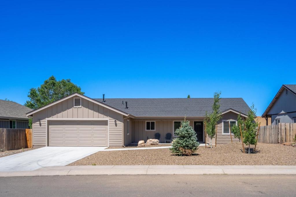 a house with a garage and a fence at Travelers Paradise, 3BR House Near Route 66 and Grand Canyon in Williams