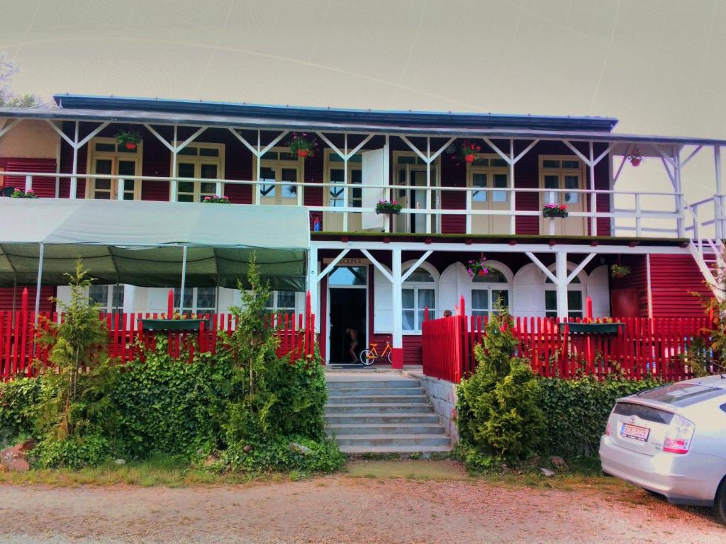 ein rotes und weißes Haus mit einem roten Zaun in der Unterkunft Kempink U Šerifa in Protiwin