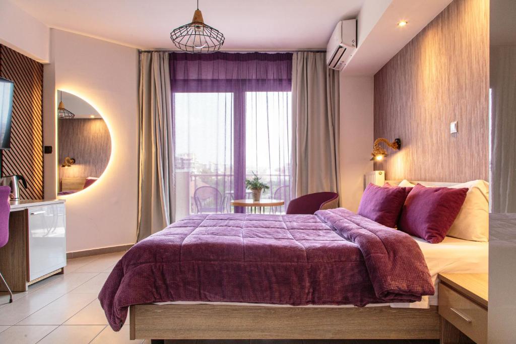 a bedroom with a large bed with a purple blanket at Limani Comfort Rooms in Thessaloniki