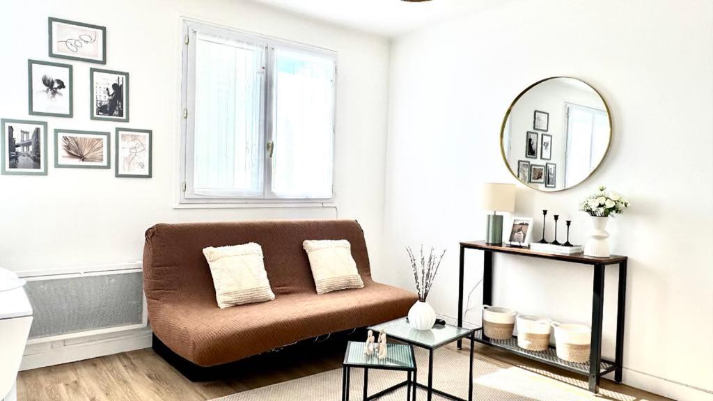 a living room with a couch and a mirror at Light & Comfort T2 Cosy Muret in Muret