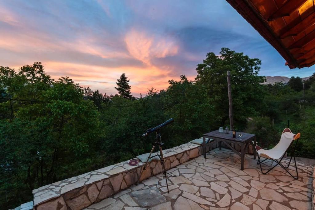 a camera and a table and a chair on a patio at Pine Forest Chalet 1400m, Cinema & Fireplace in Artemisía