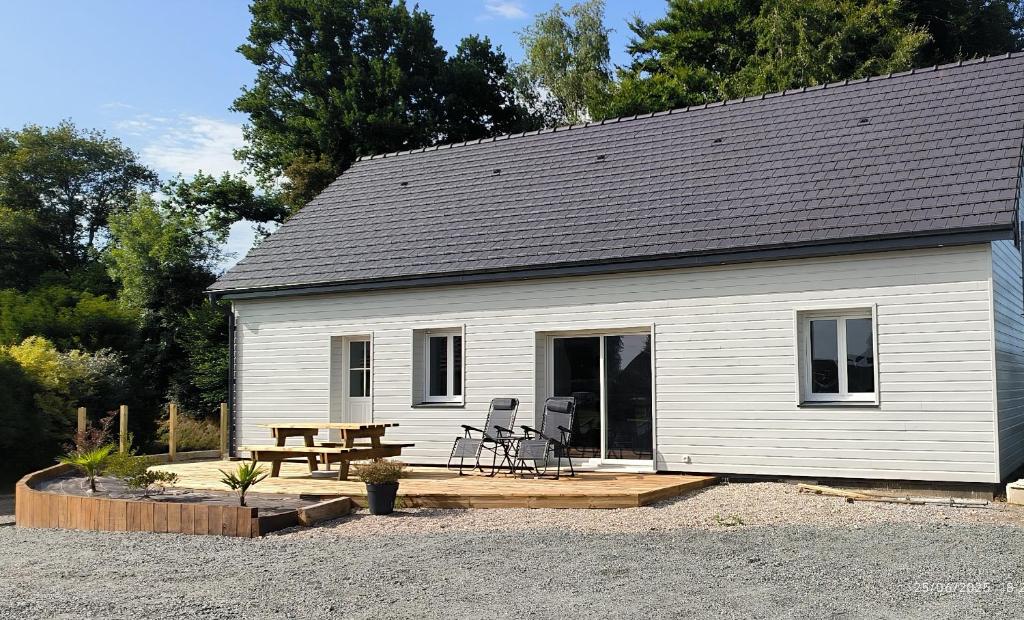 une maison blanche avec une table de pique-nique et un banc de pique-nique dans l'établissement Gîte Terre et Mer, 