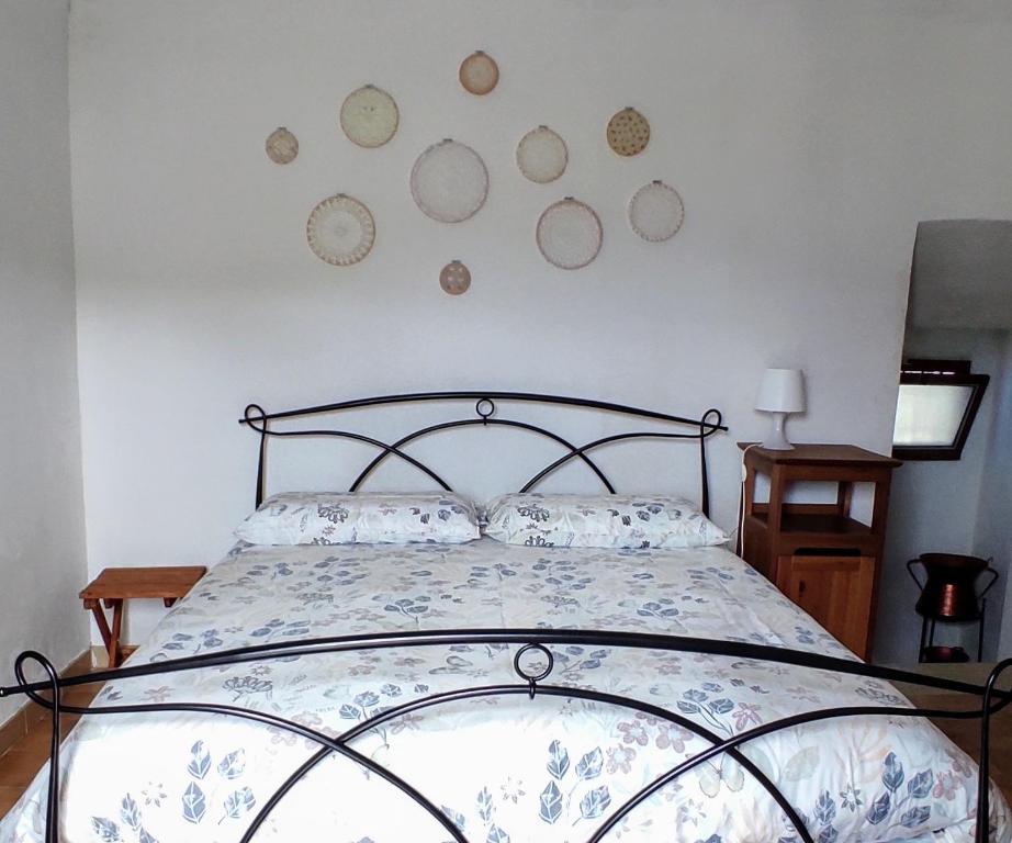 a bedroom with a bed with plates on the wall at La Casa di Fedora in Capestrano