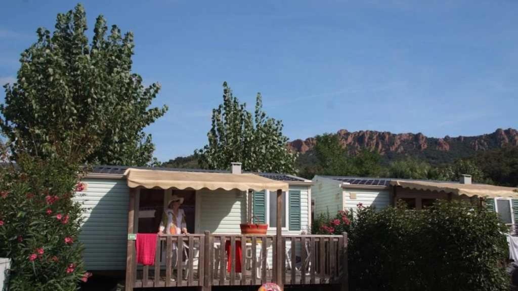une femme debout sur la terrasse couverte d'une maison dans l'établissement Camping 5 étoiles - Parc aquatique - eebafe, au Muy