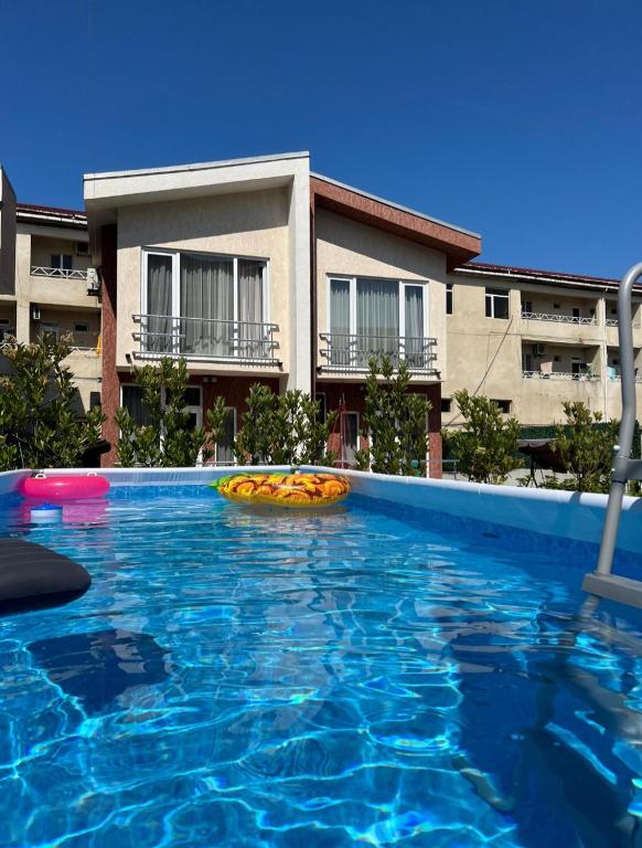 a large swimming pool with a yellow object in front of a building at Apartment IMERI in Ureki