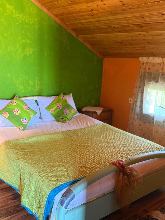 a green bedroom with a bed with green walls at Ανατολή apartment in Nea Mesangala