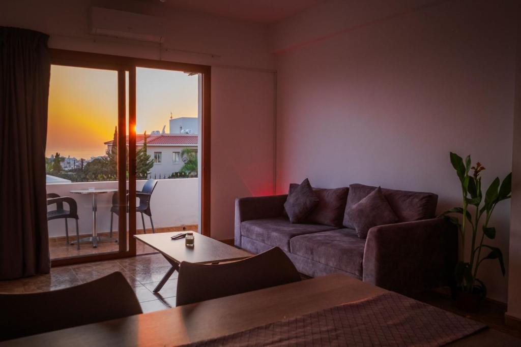 基索内加Bright sea view suite with sunset & pool Paphos的带沙发和桌子的客厅