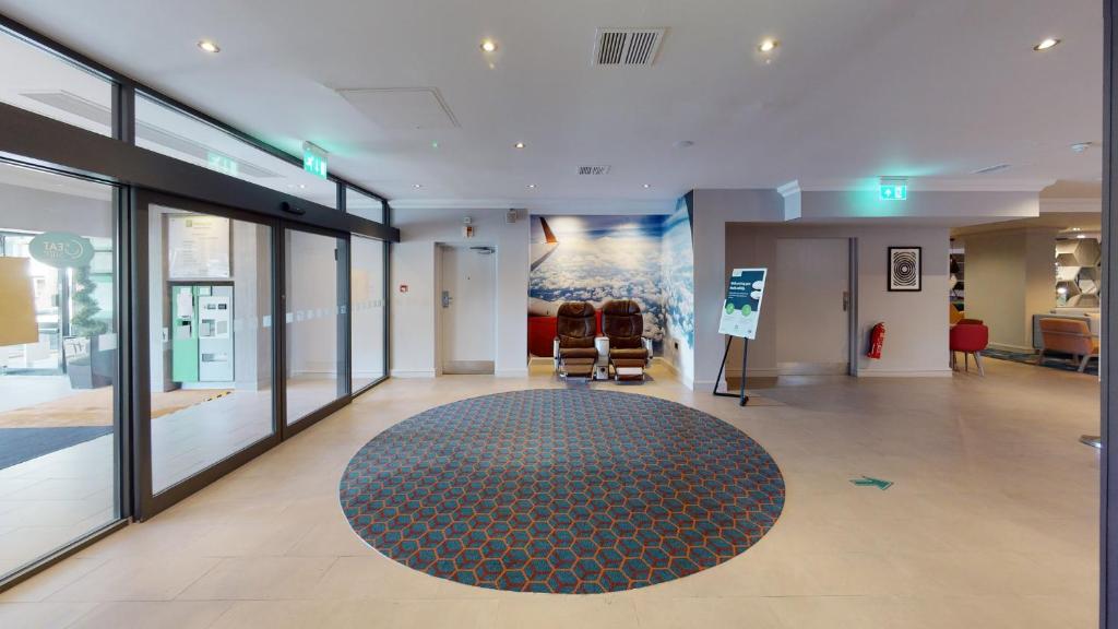 a lobby with a rug and chairs in a building at Holiday Inn - Glasgow Airport by IHG in Paisley