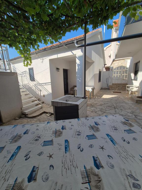 a table in the courtyard of a building at Šućur holiday home in Preko