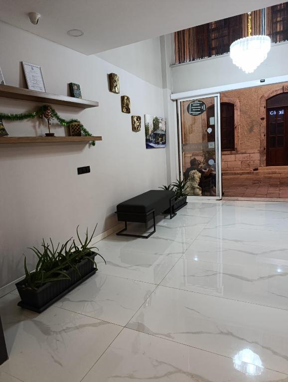 a lobby with a large white tile floor and a black bench at Grand Faik Hotel in Çeşme