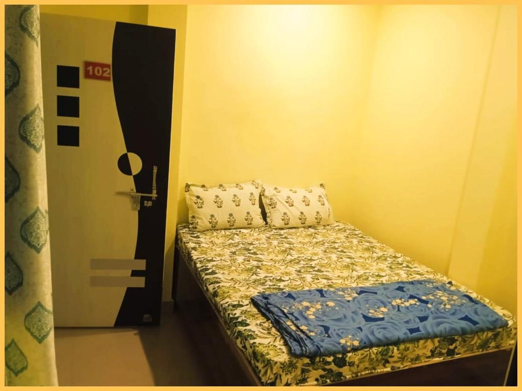 Un pat sau paturi într-o cameră la HOTEL"OM-SAI-PAYING"Near Kashi Vishwanath Temple - Provided Budget Rooms With Wi-fi Facility - Best Guest House In Varanasi