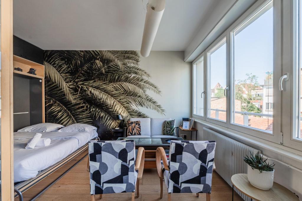une chambre avec un lit, une table et des chaises dans l'établissement L'Éclat Urbain - Studio dArchi Gare et Petite-France, à Strasbourg