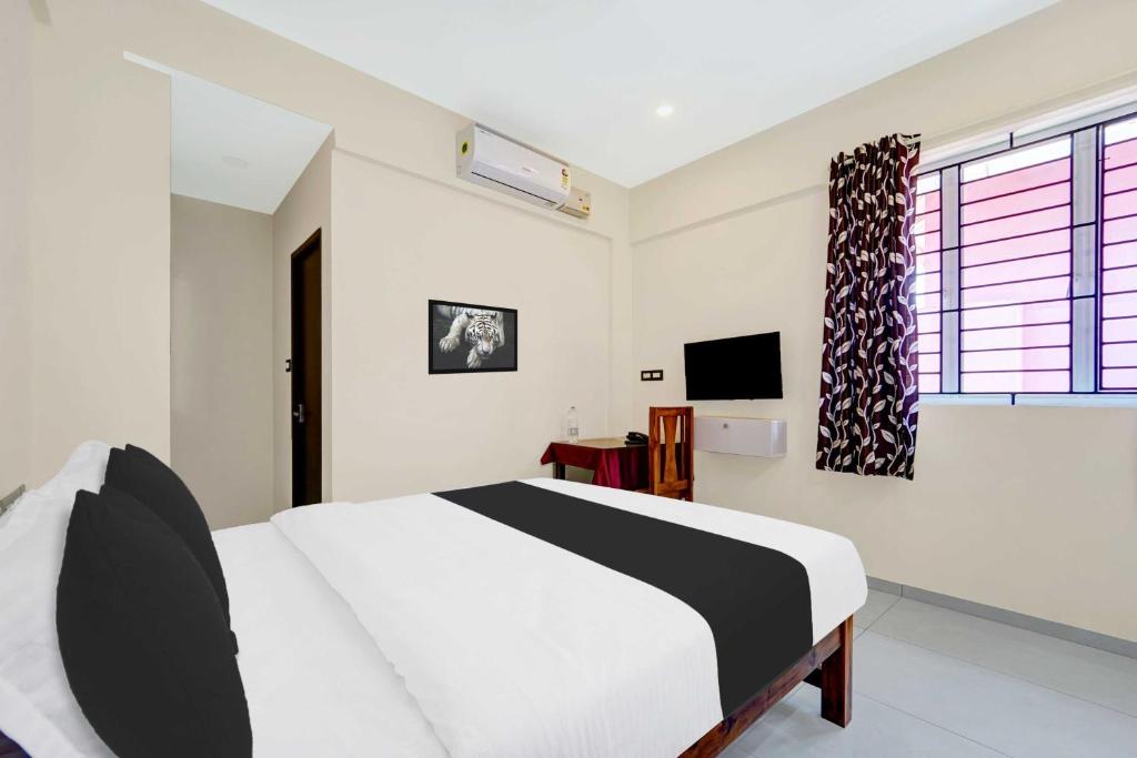 a bedroom with a bed and a television in it at Collection O Padmanabhaswamy Temple Trivandrum in Trivandrum