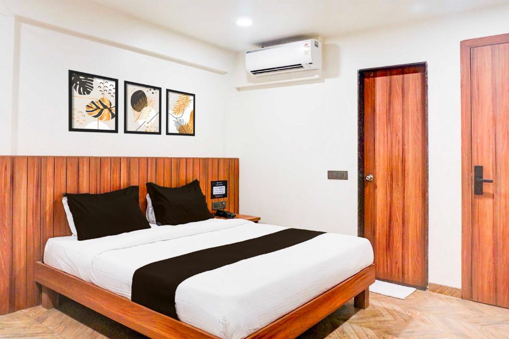 a bedroom with a large bed with a wooden headboard at Townhouse Oak Pune Ramwadi Metro Station in Pune
