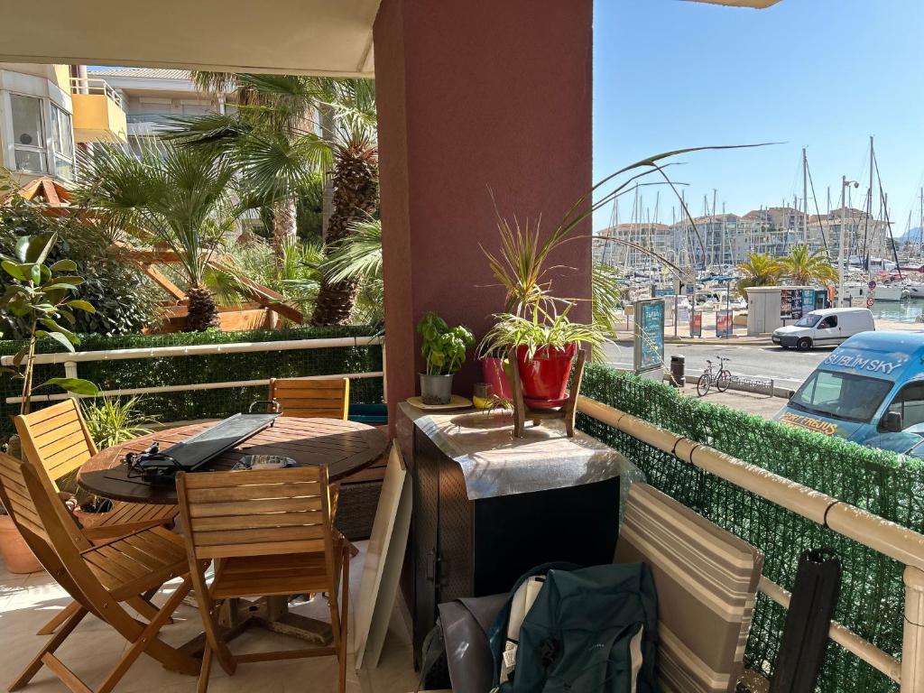 un patio avec une table et des chaises sur un balcon dans l'établissement Escale Port Fréjus vue Esterel, à Fréjus