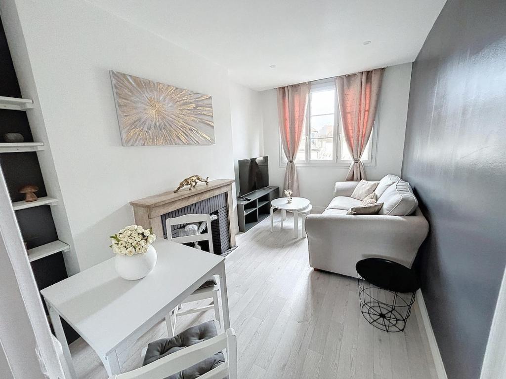a living room with a couch and a table at La Fontaine in Compiègne