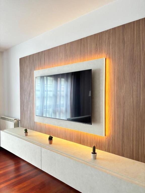 a television is mounted on a wall in a room at Parque Riera, 1 Plaza garaje in Cangas de Onís