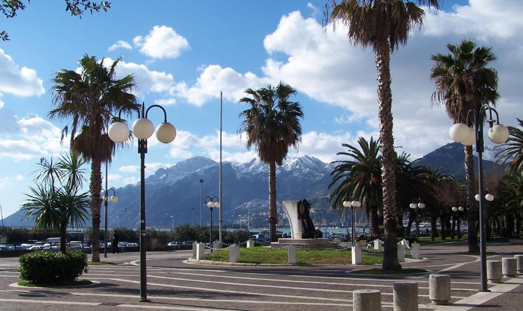 uma rua com palmeiras e montanhas ao fundo em Sole e Mare em Salerno