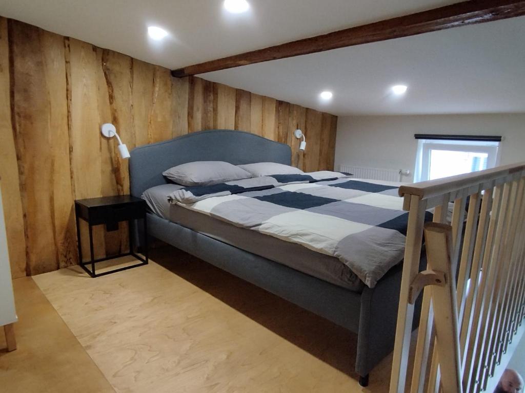 リエパーヤにあるCourtyard Condo Summer Breezeのベッドと木の壁がある寝室