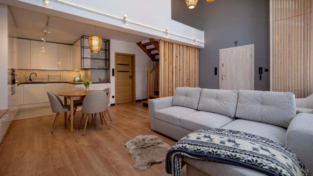 salon z kanapą i stołem oraz kuchnia w obiekcie Apartamenty Sun & Snow Ustroń Przy Rynku w Ustroniu