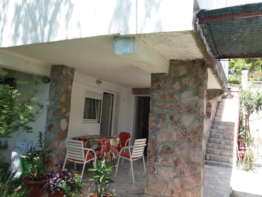 a house with a table and chairs on a patio at Apartment for 2 in the house in Sutomore