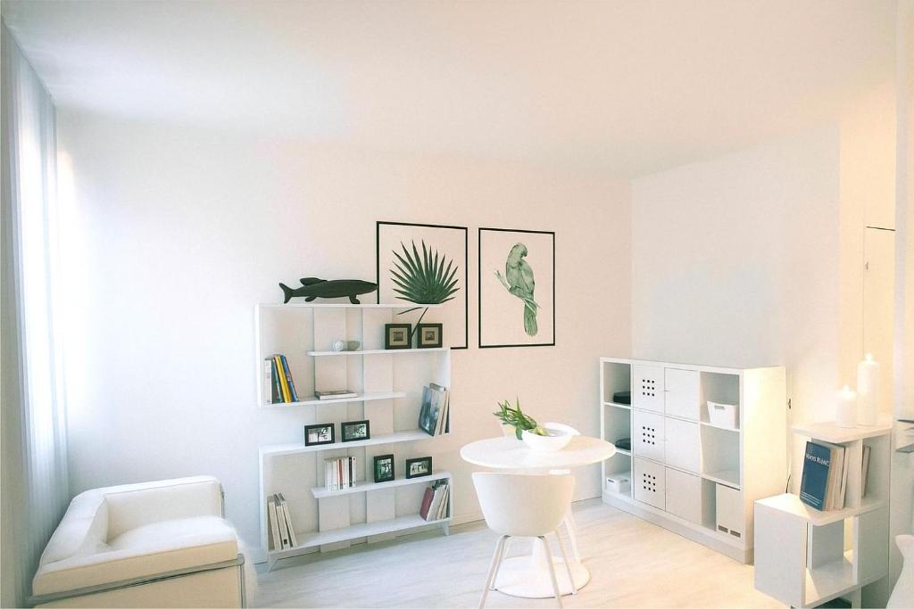 - un salon blanc avec une chaise blanche et une table dans l'établissement Joli appartement au cœur de la ville, à LʼIsle-sur-la-Sorgue