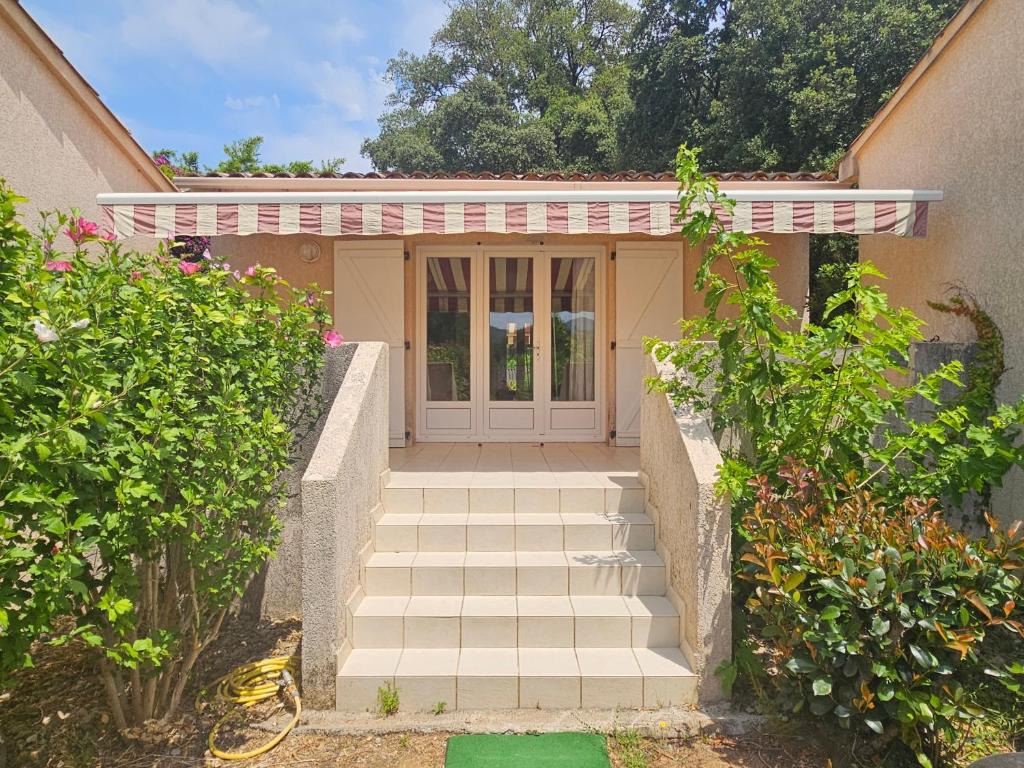 une maison avec un escalier menant à la porte d'entrée dans l'établissement T2 45 M2 climatisé proche plage, à Eccica-Suarella