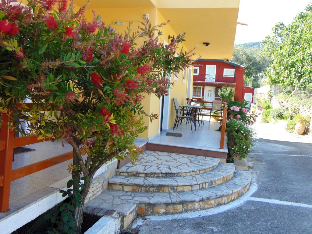 una casa con escaleras que conducen a un patio con flores en Maria Apartments - Roumanis, en Liapades