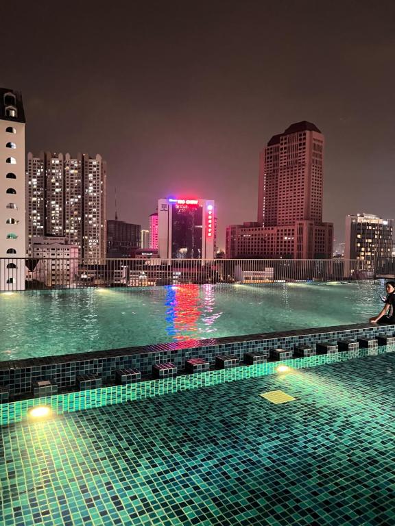 a swimming pool with a city skyline at night at Chambers by Lumira Haven Klcc in Kuala Lumpur