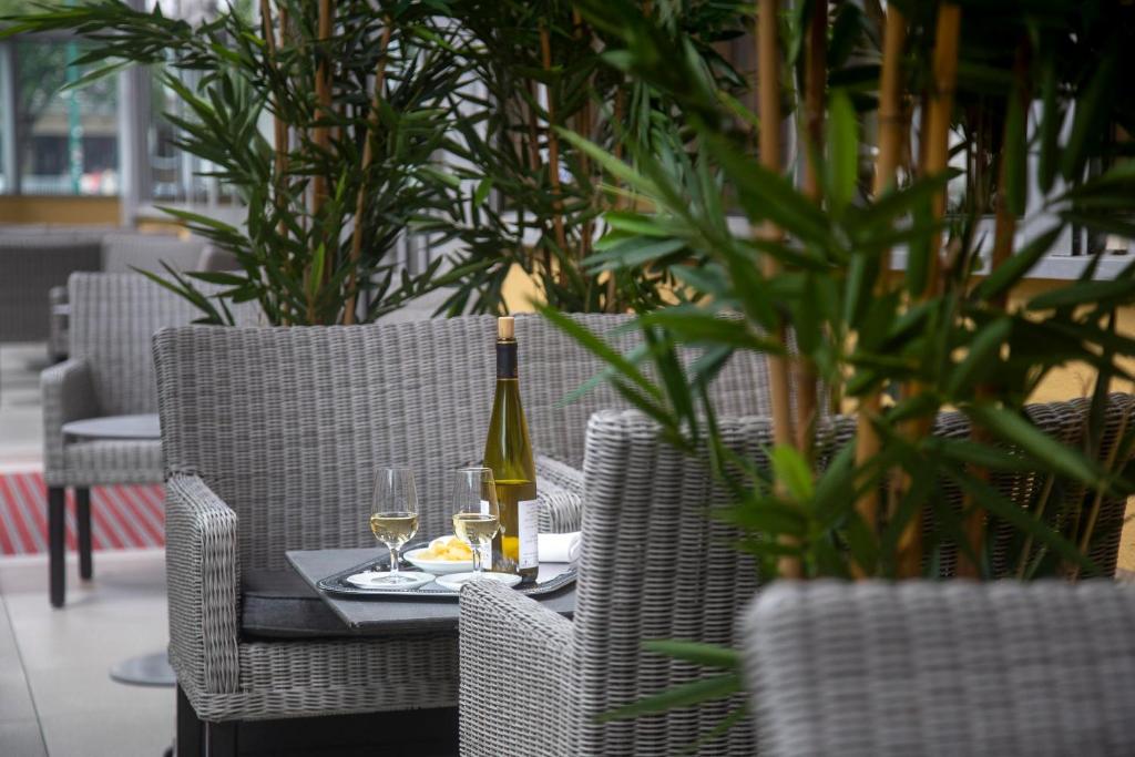 - une table avec une bouteille de vin et deux verres dans l'établissement Hôtel Paradis, à Lourdes