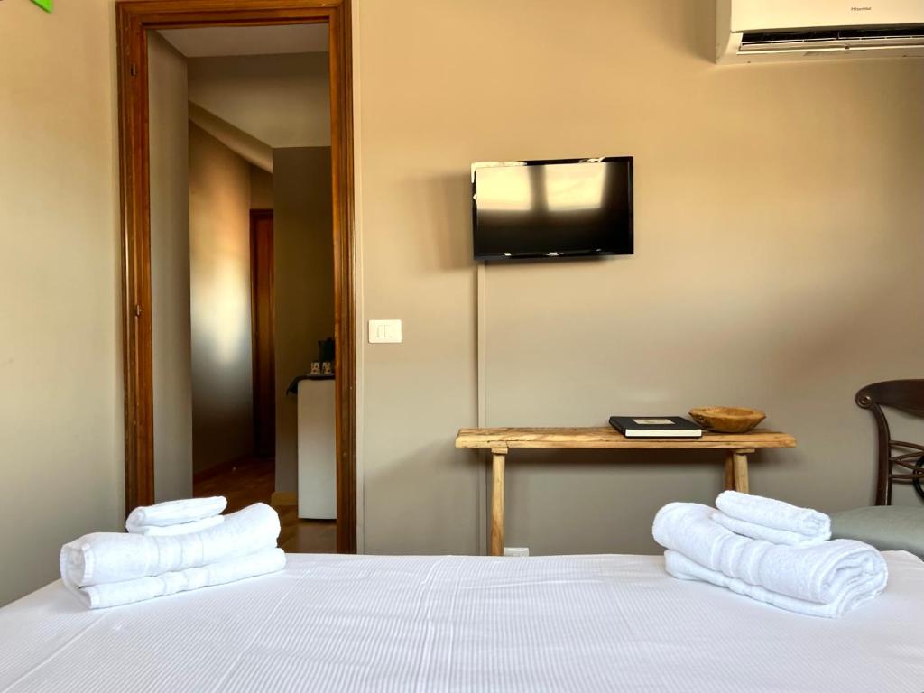 een slaapkamer met een bed en een televisie aan de muur bij La Mansardina in Parma