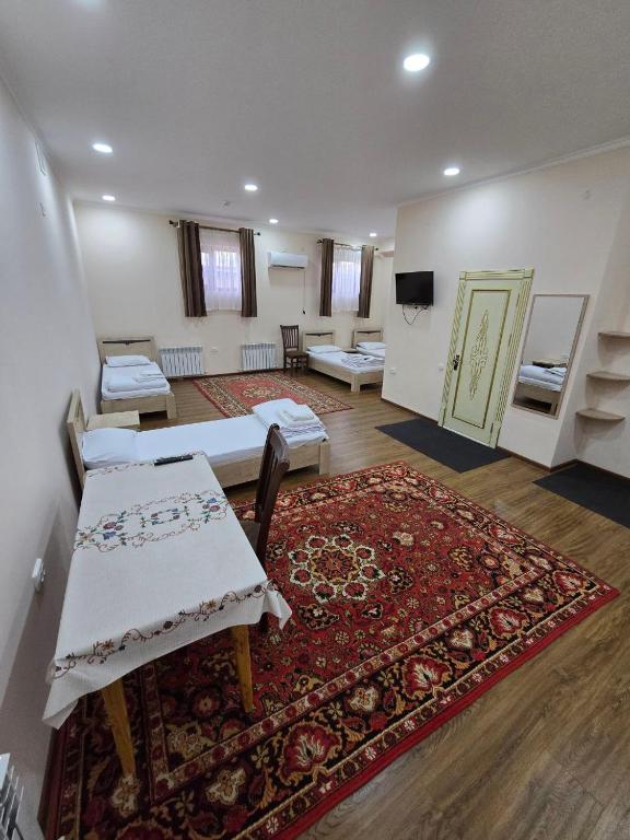 a large room with two beds and a rug at Donish Hotel in Bukhara