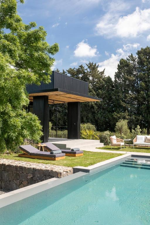 a house with a swimming pool next to a house at Scorzamara Country Lodges - Retreats with Private Pool or Jacuzzi in Carlentini