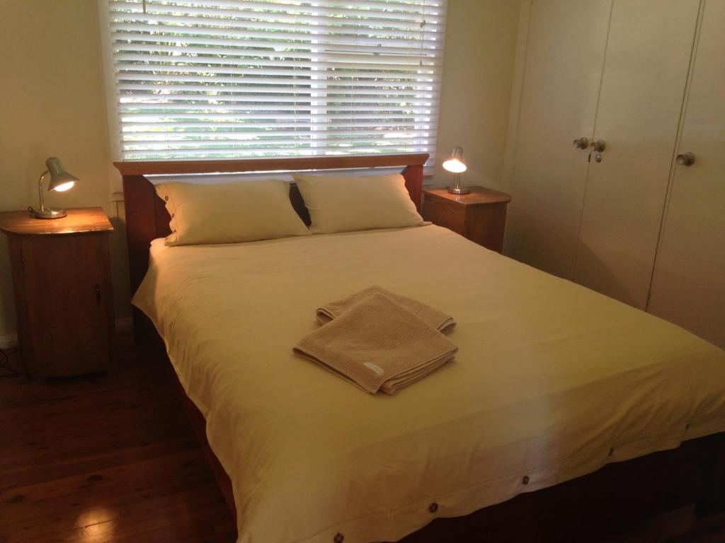 a bedroom with a large white bed with two lamps at Hyams Beach - A Secret Treasure in Hyams Beach