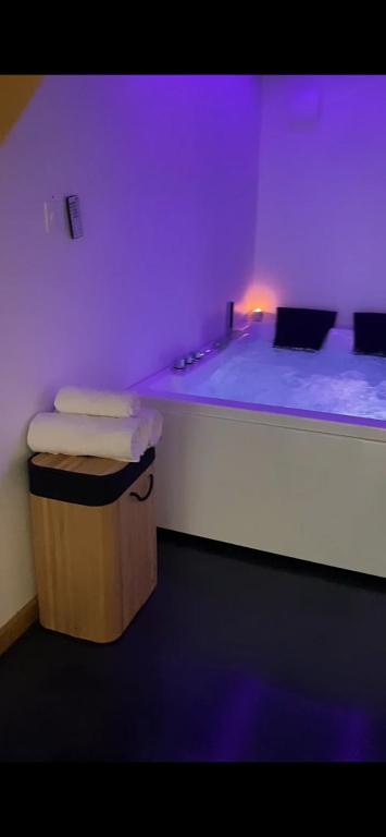 - un lit dans une chambre violette dans l'établissement Retour à l essentiel, à Yvré-le-Pôlin