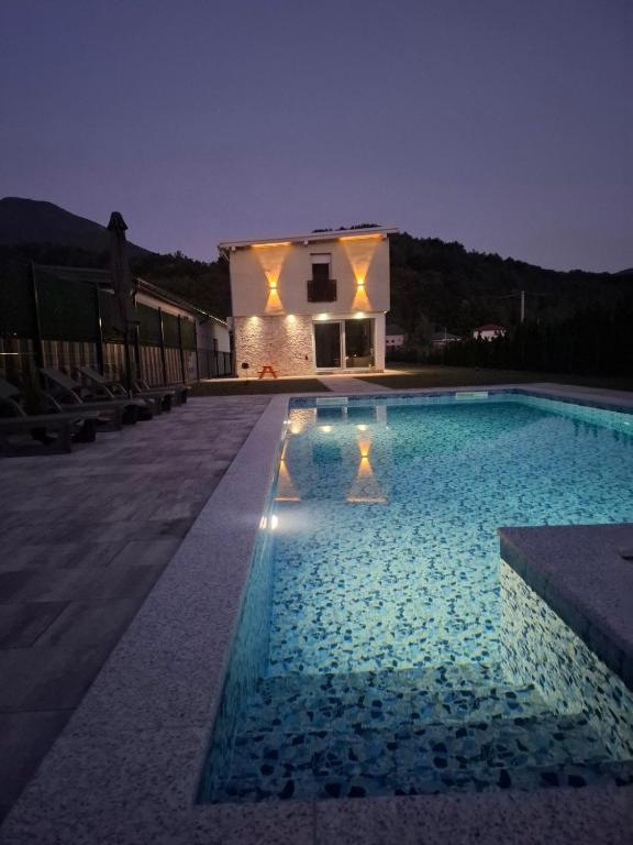 a swimming pool in front of a house at night at Villa L&M in Bihać