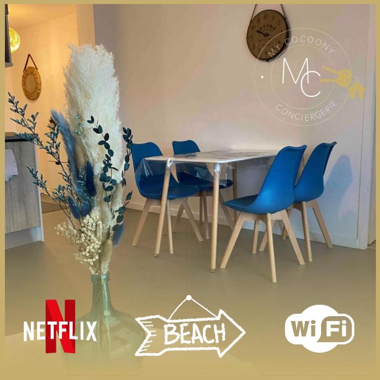 une table avec des chaises bleues et un vase avec des fleurs dans l'établissement L’horizon bleu, à Saint-Hilaire-de-Riez