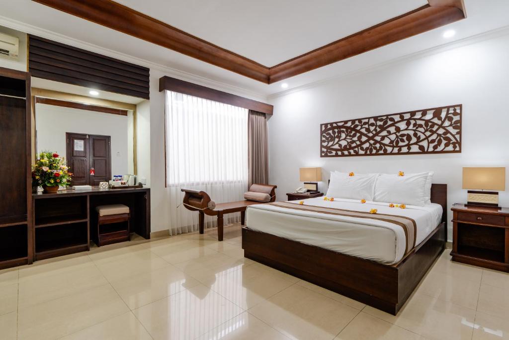 Postel nebo postele na pokoji v ubytování Dewi Sri Hotel