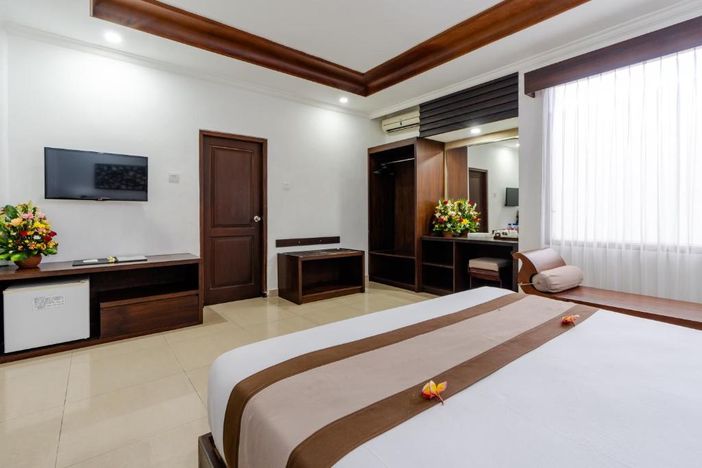 Postel nebo postele na pokoji v ubytování Dewi Sri Hotel