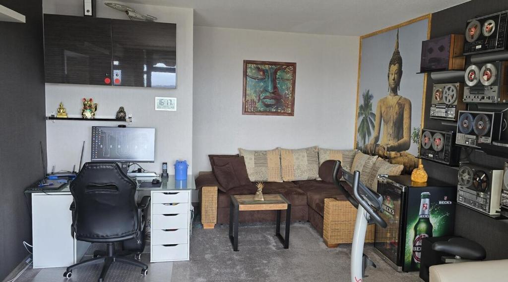 a living room with a couch and a desk with a computer at Let's RelaxX 1703 in Mülheim an der Ruhr