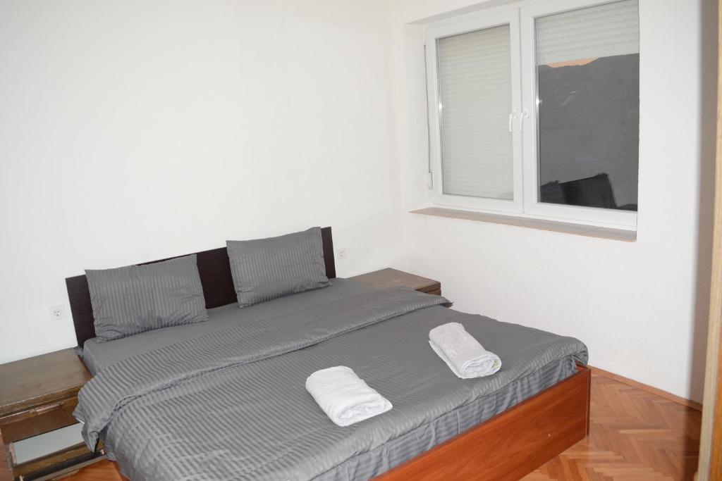 a bed in a white room with a window at Luka Apartman in Bitola