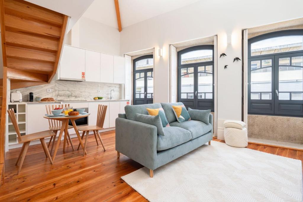ein Wohnzimmer mit einer blauen Couch und einer Küche in der Unterkunft Framed Corner by Portugal Active in Porto