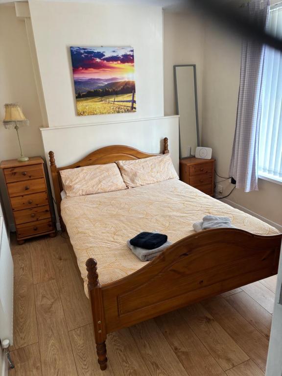 Schlafzimmer mit einem Holzbett und Holzboden in der Unterkunft Glasgow house in Londonderry County Borough