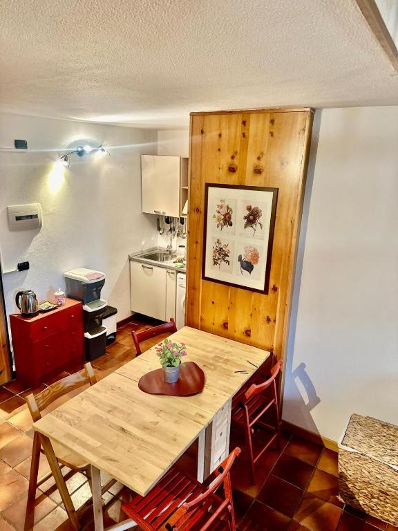 a kitchen with a wooden table in a room at Il Nido di Pila , Panoramic Mountain View near Ski Lifts in Pila