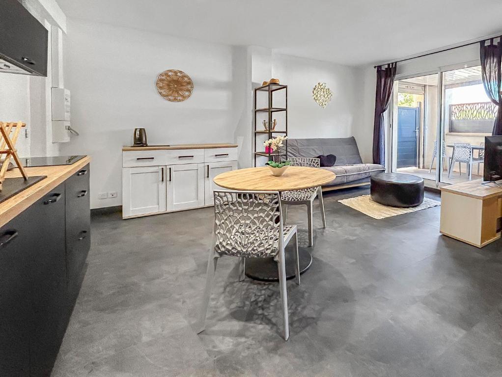 une cuisine avec une table et un salon dans l'établissement Appartement à 150m des plages, à Valras-Plage