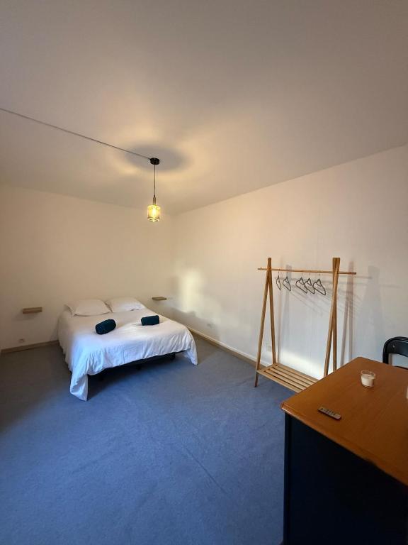 a bedroom with a bed and a desk and a table at Grand T2 en centre-ville quartier historique in Fontenay-le-Comte