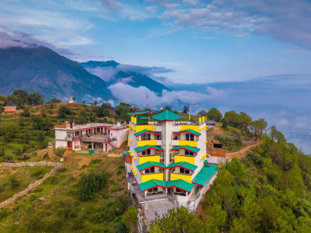 un edificio colorido en la cima de una colina en The Hosteller Dharamshala, en Dharamshala