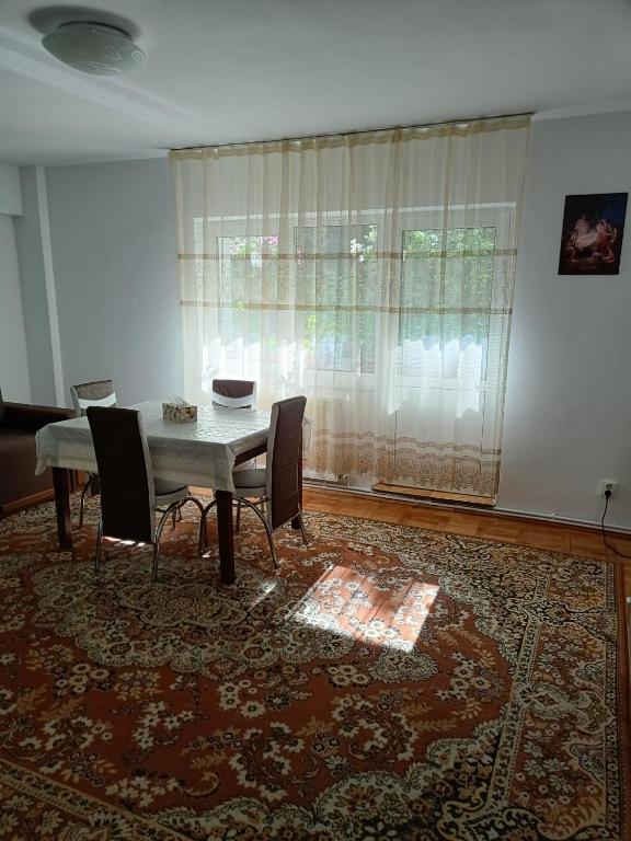 a dining room with a table and chairs and a window at Sunny Apartment in Predeal