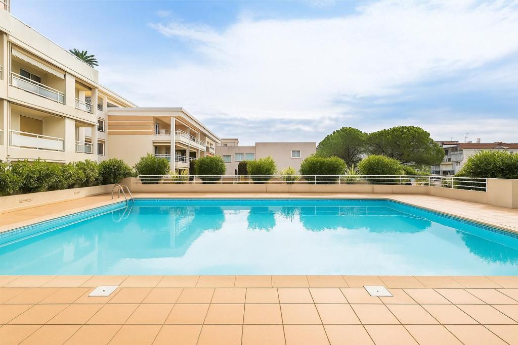 une piscine dans un complexe d'appartements avec un immeuble dans l'établissement Port Azur, à Vallauris